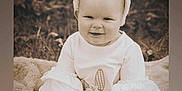 Adalynn is registered to the contest to win money with this photo: ammunition, baby, babylaughing, ball, clothing, face, food, grass, grenade, happy, hat, head, laughing, person, photography, plant, portrait, sitting, smile, weapon