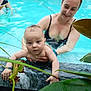baby, woman, swimming_pool, water, people, child, holding, smiling, leaf, nature, outdoor, reaching, adult, crowd, swimwear, blue_water, skin, family, summer, play
