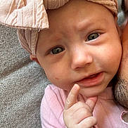 Alma participe au concours pour gagner de l'argent avec cette photo : baby, infant, pink_bow, headwear, hand, face, eyes, expression, person, skin, clothing, fabric, texture, adult, closeup, portrait, cute, indoor, curious, pointing