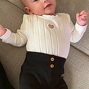 Alma participe au concours pour gagner de l'argent avec cette photo : baby, black_pants, buttons, child, clothing, couch, eyes, fabric, face, fingers, hand, heart_cutout, indoor, infant, lying_down, person, portrait, smile, texture, white_top