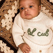 Kaizen joined the competition — help win amazing prizes! baby, blanket, child, clothing, cozy, crochet, cute, expression, face, hand, indoors, infant, knitwear, laying_down, portrait, relaxed, skin, sweater, warm_tones, young