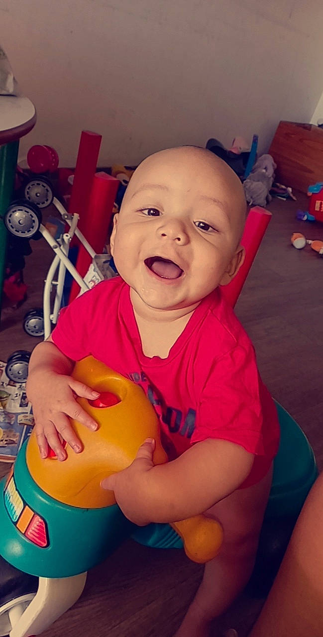 Layne participe au concours pour gagner de l'argent avec cette photo : arm, baby, baby_playing_with_toys, baby_toddler_clothing, cheek, child, finger, happy, joint, leg, mouth, nose, orange, person, pink, shorts, skin, smile, t_shirt, thumb