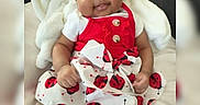 Kadence is registered to the contest to win money with this photo: baby, child, infant, smile, dress, headband, ladybug_pattern, red, white, blanket, soft, cute, playful, indoors, sitting, happy, person, clothing, portrait, young