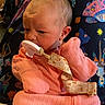 baby, baby_seat, calm, child, colorful, cozy, face, hands, harness, head, indoor, infant, looking_down, onesie, pacifier, photograph, pink_outfit, portrait, seated, space_pattern