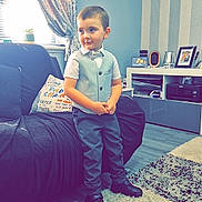Corey joined the competition — help win amazing prizes! bow_tie, boy, carpet, child, couch, curtains, decor, expression, floor, formal_clothing, home, light, living_room, photographs, pillow, shelves, shoes, standing, vest, window