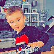 Corey joined the competition — help win amazing prizes! toddler, child, toy_car, sweater, blue_eyes, indoor, living_room, furniture, table, coloring_book, chair, photography, person, face, play, home, smile, cute, young_child, decor