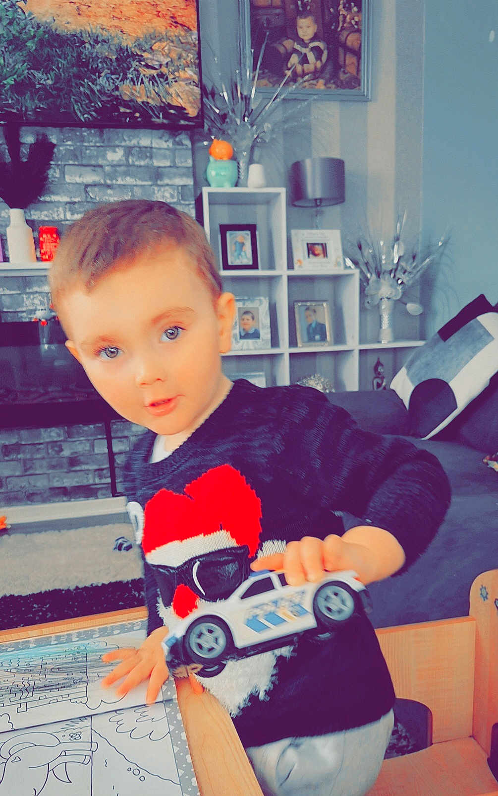 Corey joined the competition — help win amazing prizes! toddler, child, toy_car, sweater, blue_eyes, indoor, living_room, furniture, table, coloring_book, chair, photography, person, face, play, home, smile, cute, young_child, decor