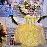 child, girl, princess, dress, yellow_dress, crown, smile, holiday, christmas, decorations, lights, garland, fireplace, indoor, floor, boots, pose, festive, celebration, portrait
