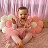 Lilya participe au concours pour gagner de l'argent avec cette photo : baby, child, pink, tutu, smiling, clapping, plush_pillow, flower_pillow, soft_blanket, indoors, cute, happy, person, sitting, infant, head, face, legs, barefoot, background