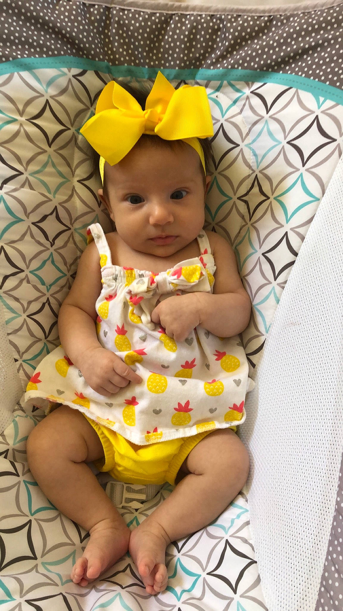 Madilyn joined the competition — help win amazing prizes! baby, baby_products, baby_toddler_clothing, child, costume_accessory, foot, hair_accessory, hand, headband, headpiece, headwear, human_body, nose, person, sitting, toddler, yellow