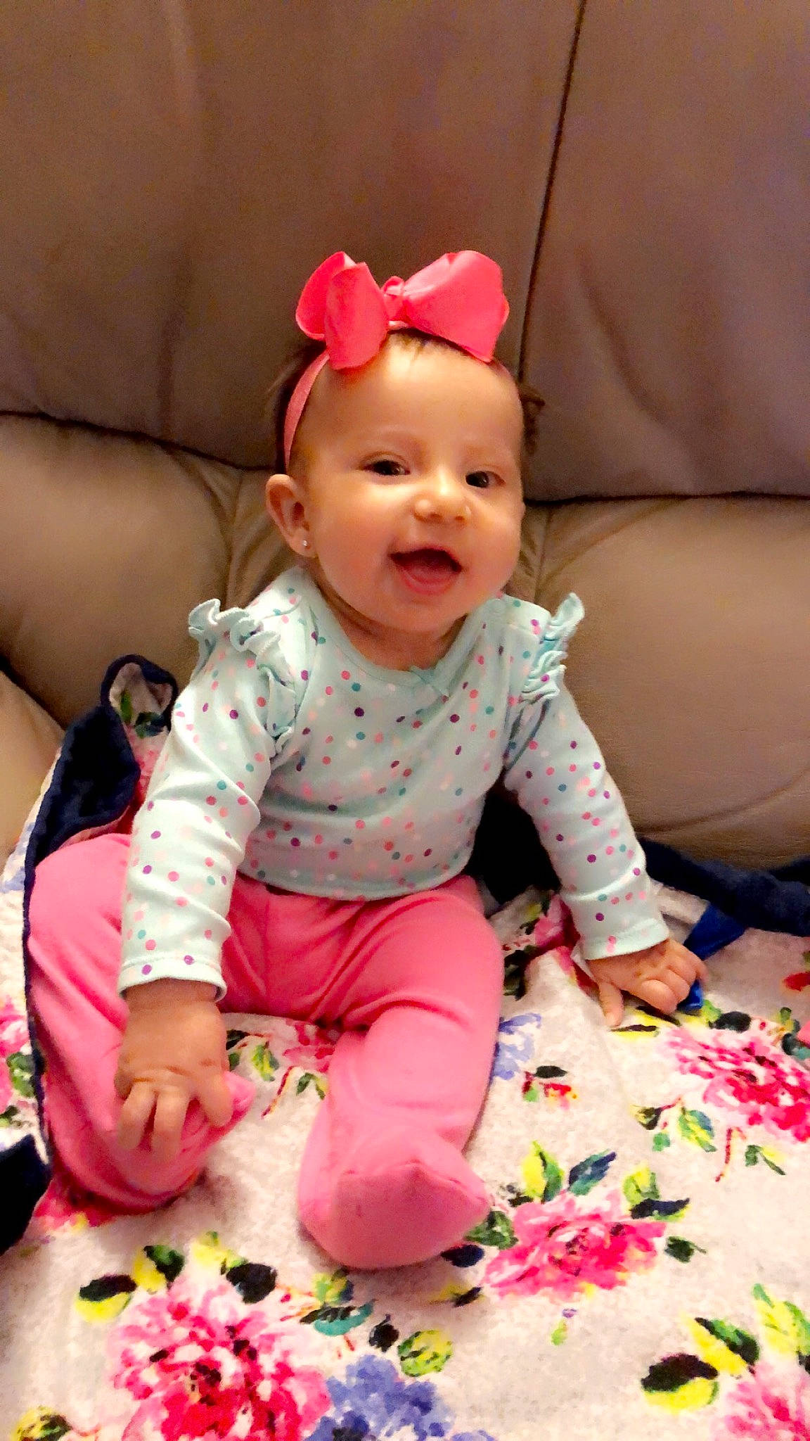 Madilyn is registered to the contest to win money with this photo: baby, baby_products, baby_toddler_clothing, cheek, child, comfort, costume_accessory, couch, hair_accessory, headband, headpiece, human_body, linens, living_room, nightwear, nose, person, pink, sitting, sock