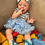 Winter joined the competition — help win amazing prizes! baby, child, smile, blue_dress, headband, sitting, blanket, couch, footwear, nike_shoes, happy, infant, cute, indoors, playful, toddler, face, apparel, colorful, cozy