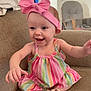baby, child, smiling, happy, pink_bow, headband, striped_dress, sitting, couch, indoor, shoes, cute, infant, portrait, person, furniture, home, room, joy, expression