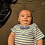 arm, baby, blanket, bow_tie, child, clothing, curious, cute, expression, eyes, fabric, face, hand, indoor, infant, laying_down, person, skin, striped_shirt, texture