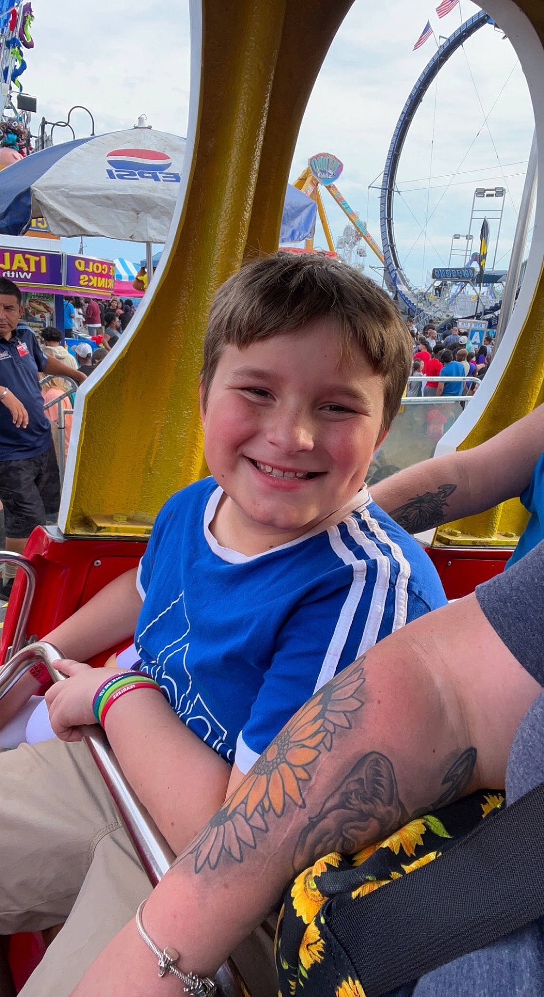 Maddox is registered to the contest to win money with this photo: blue, elbow, electric_blue, event, fun, happy, human_leg, joy, leisure, muscle, organ, outdoor_recreation, person, photograph, recreation, smile, summer, t_shirt, temporary_tattoo, thigh