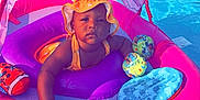 Soraya joined the competition — help win amazing prizes! baby, child, pool, float, floatie, water, swim, sunhat, orange_hat, pink_float, purple_cushion, toy, outdoor, summer, sunny, fence, grass, swimming_pool, infant, relaxing