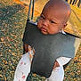 Soraya joined the competition — help win amazing prizes! baby, swing, playground, outdoor, child, fence, trees, socks, clothing, seat, park, sunlight, grass, nature, infant, person, cute, expression, fun, play