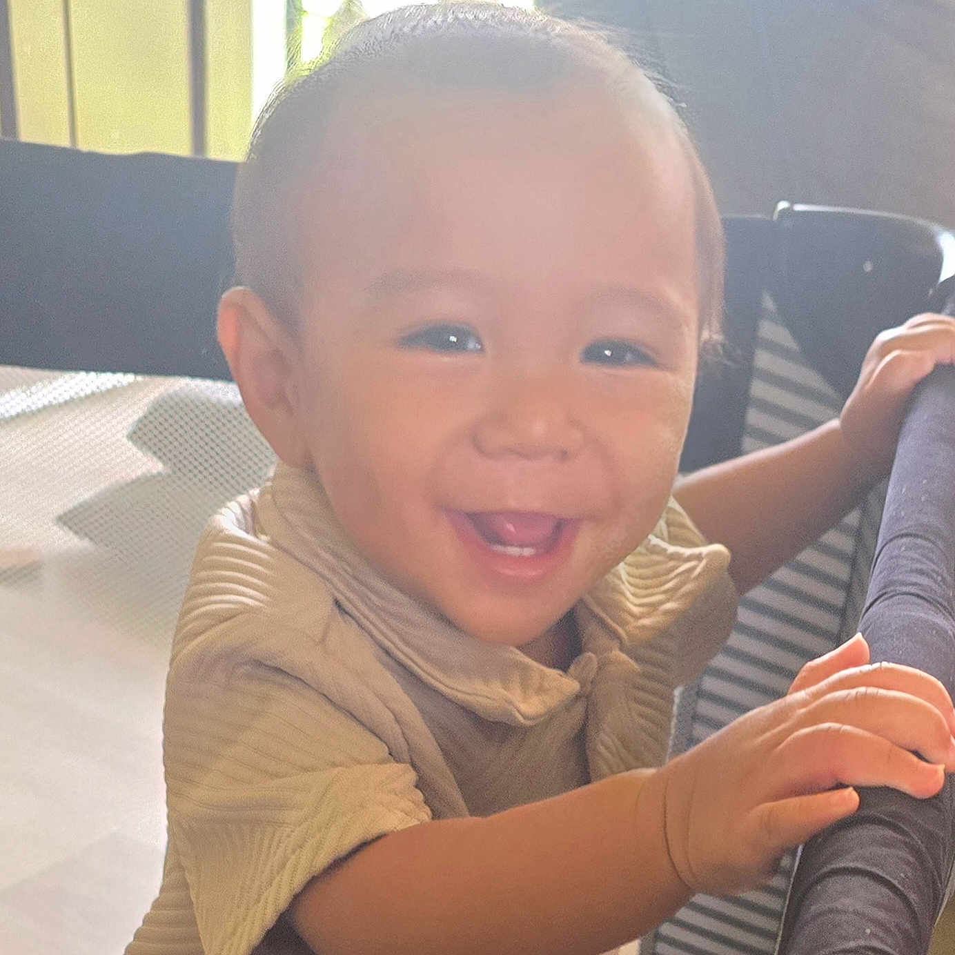 Zixton is registered to the contest to win money with this photo: toddler, child, smile, happy, face, hand, clothing, playpen, indoor, portrait, baby, person, young_child, light, window, furniture, cute, expression, holding, warm