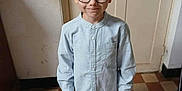 Timéo a rejoint le concours — aidez-le/la à gagner de superbes lots ! child, boy, glasses, shirt, pants, shoes, standing, indoor, floor, door, smile, portrait, young, person, casual_clothing, light, window_light, happy, home, checkered_floor