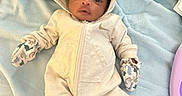 Jordan joined the competition — help win amazing prizes! baby, infant, hooded_onesie, mittens, blanket, blue_blanket, laying_down, cozy_clothing, cute, small_hands, newborn, face, portrait, indoors, soft_texture, child, person, sleepwear, comfort, warm