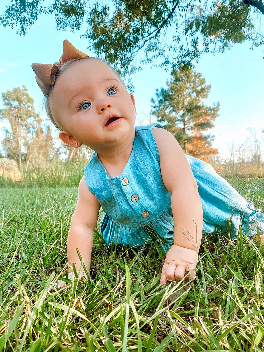 Adalee joined the competition — help win amazing prizes! azure, baby, baby_toddler_clothing, dress, electric_blue, facial_expression, fun, grass, grass_family, grassland, happy, meadow, people_in_nature, person, plant, skin, sky, standing, sunlight, toddler