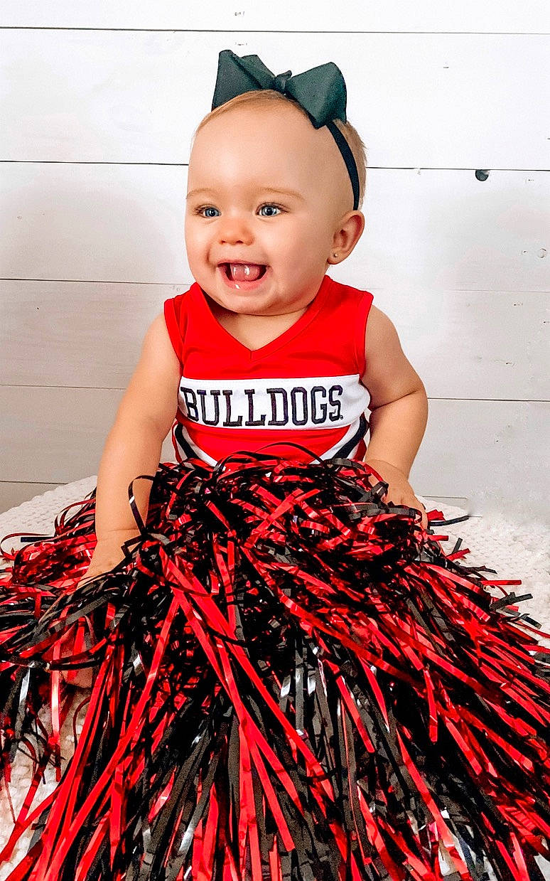 Adalee is registered to the contest to win money with this photo: baby_toddler_clothing, clothing, day_dress, dress, event, face, fashion_design, happy, joy, magenta, neck, one_piece_garment, outerwear, person, pink, red, sleeve, sleeveless_shirt, smile, t_shirt