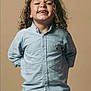 Maïdine a rejoint le concours — aidez-le/la à gagner de superbes lots ! child, curly_hair, smiling, gap_tooth, blue_shirt, casual_clothing, standing, portrait, happy, cute, kid, button_up, long_sleeves, jeans, hands_behind_back, studio, beige_background, light, person, fashion