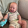 Daniel joined the competition — help win amazing prizes! baby, smiling, infant, couch, onesie, toy, dinosaur_print, happy, indoors, child, person, cute, sitting, blanket, plush, furniture, home, relaxing, skin, face