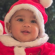 Nivaan joined the competition — help win amazing prizes! baby, child, face, smile, santa_hat, christmas, holiday, red_clothing, festive, fur_trim, cute, portrait, young_child, happy, indoors, chubby_cheeks, costume, closeup, infant, seasonal