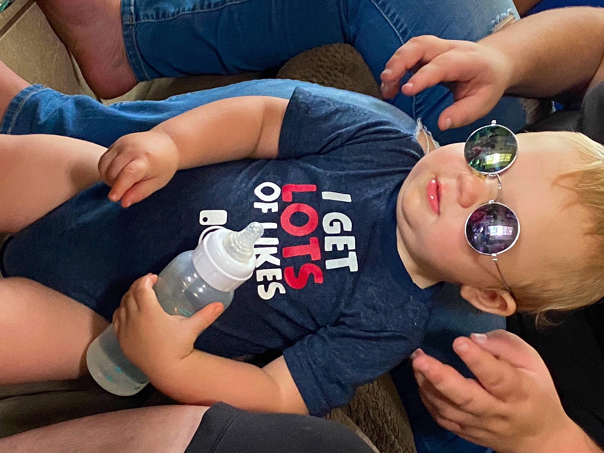 Liam joined the competition — help win amazing prizes! baby, baby_products, baby_toddler_clothing, bottle, bracelet, denim, drinking, finger, goggles, hand, knee, lap, nail, person, plastic_bottle, sock, sunglasses, thigh, thumb, water_bottle