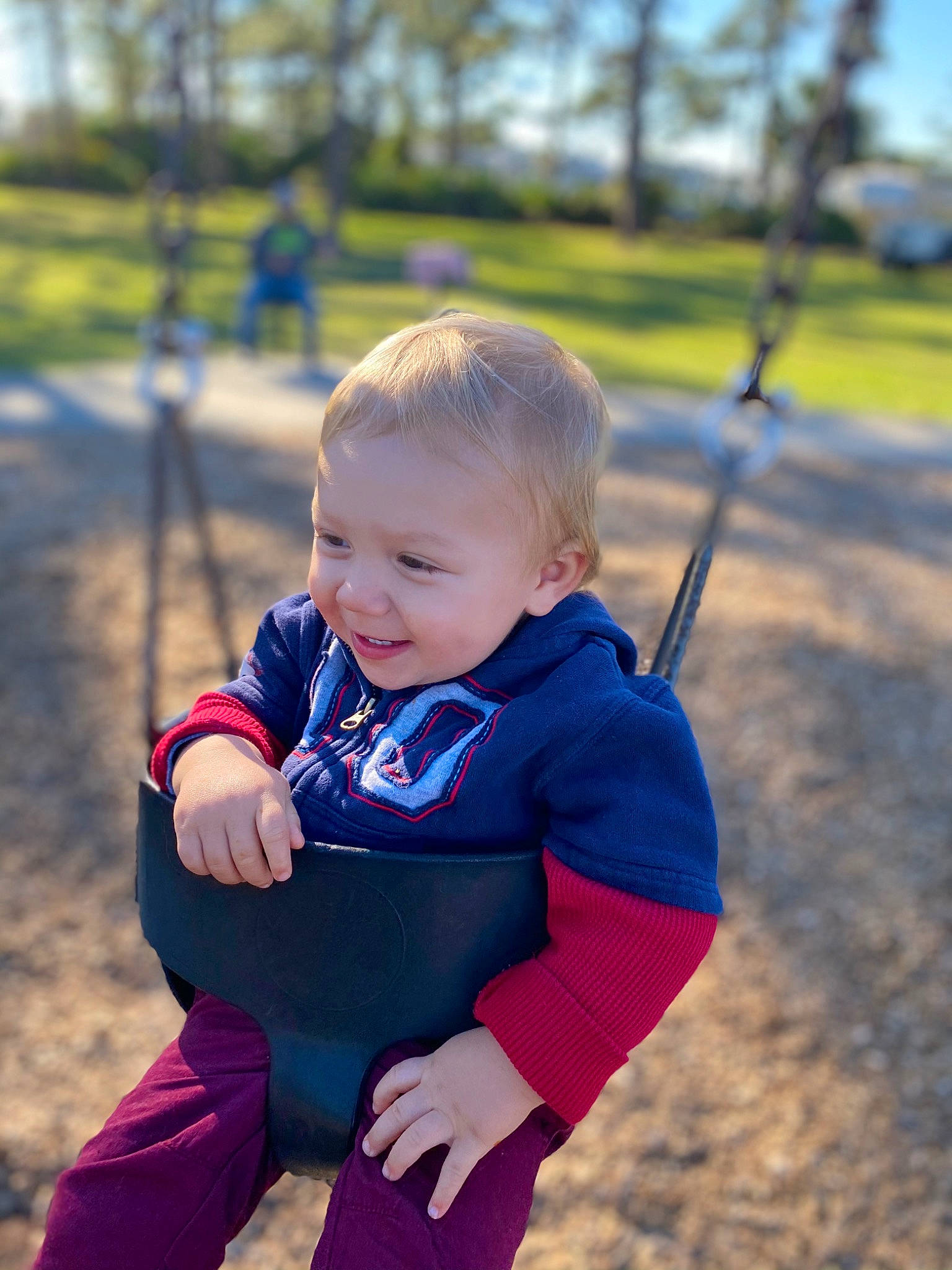 Liam is registered to the contest to win money with this photo: active_pants, baby, baby_laughing, baby_toddler_clothing, child, electric_blue, human_body, laugh, outdoor_play_equipment, overall, people_in_nature, person, play, playground, public_space, sleeve, spring, sweatpant, swing, toddler