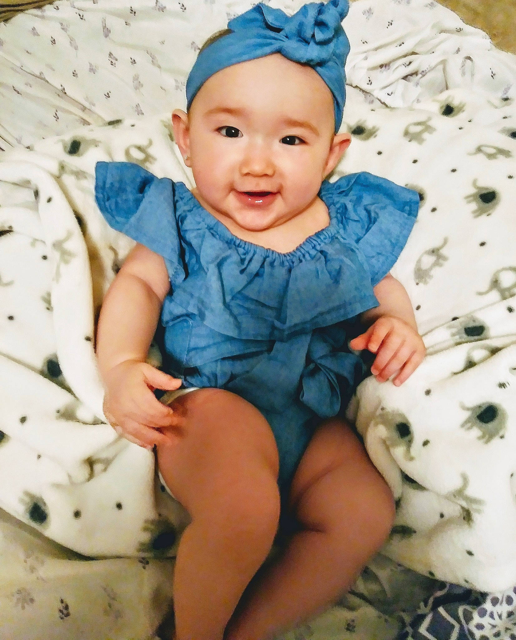 Lani is registered to the contest to win money with this photo: baby, baby_bloomers, baby_toddler_clothing, blue, child, child_model, clothing, fashion_accessory, hair_accessory, headband, headgear, pattern, person, sitting, sleeve, smile, toddler
