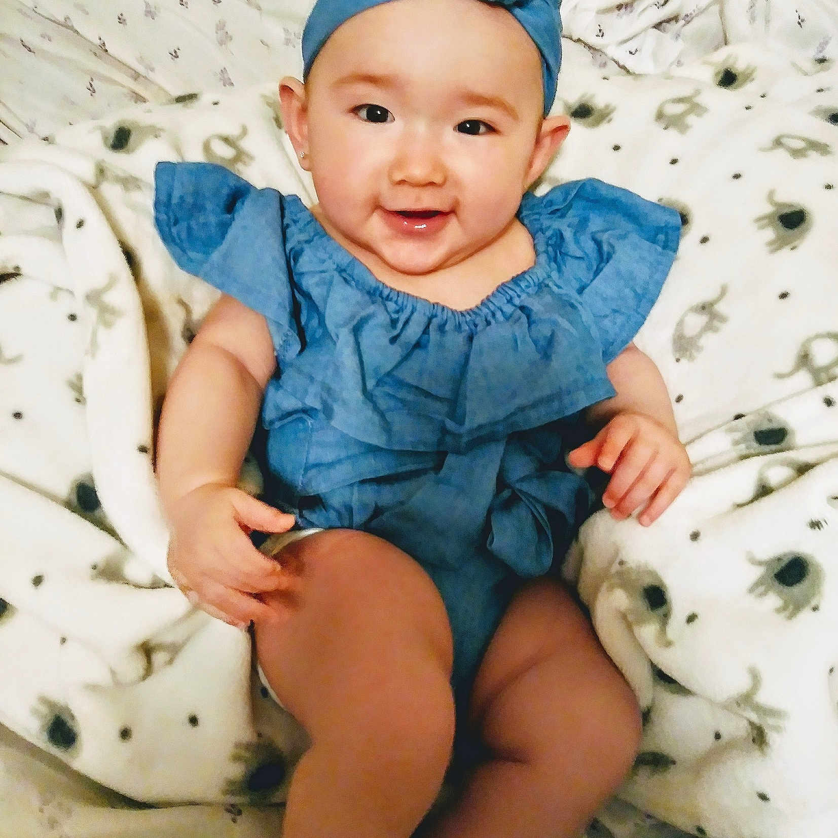 Lani is registered to the contest to win money with this photo: baby, baby_bloomers, baby_toddler_clothing, blue, child, child_model, clothing, fashion_accessory, hair_accessory, headband, headgear, pattern, person, sitting, sleeve, smile, toddler