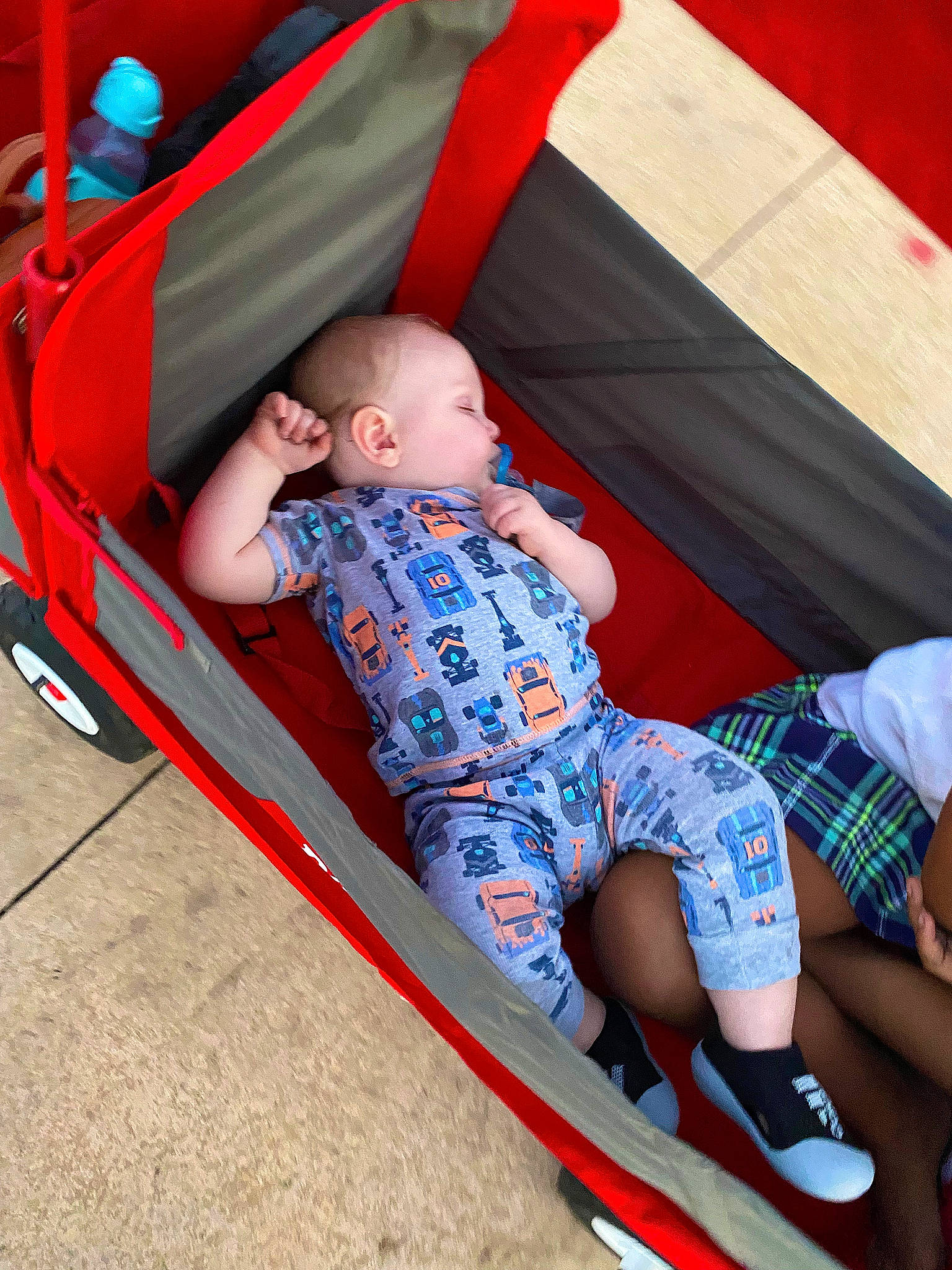 Daniel is registered to the contest to win money with this photo: baby, baby_toddler_clothing, child, comfort, fun, grass, human_leg, knee, lap, leg, leisure, outdoor_play_equipment, pattern, person, play, recreation, shorts, sitting, sock, thigh