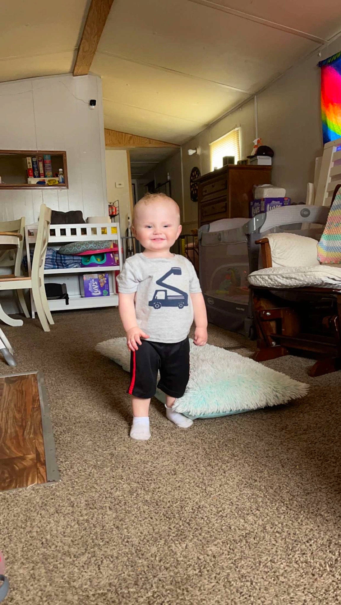 Daniel is registered to the contest to win money with this photo: baby, child, drawer, floor, flooring, fun, hardwood, home, home_appliance, joy, living_room, person, play, refrigerator, room, shelf, shelving, shorts, standing, t_shirt