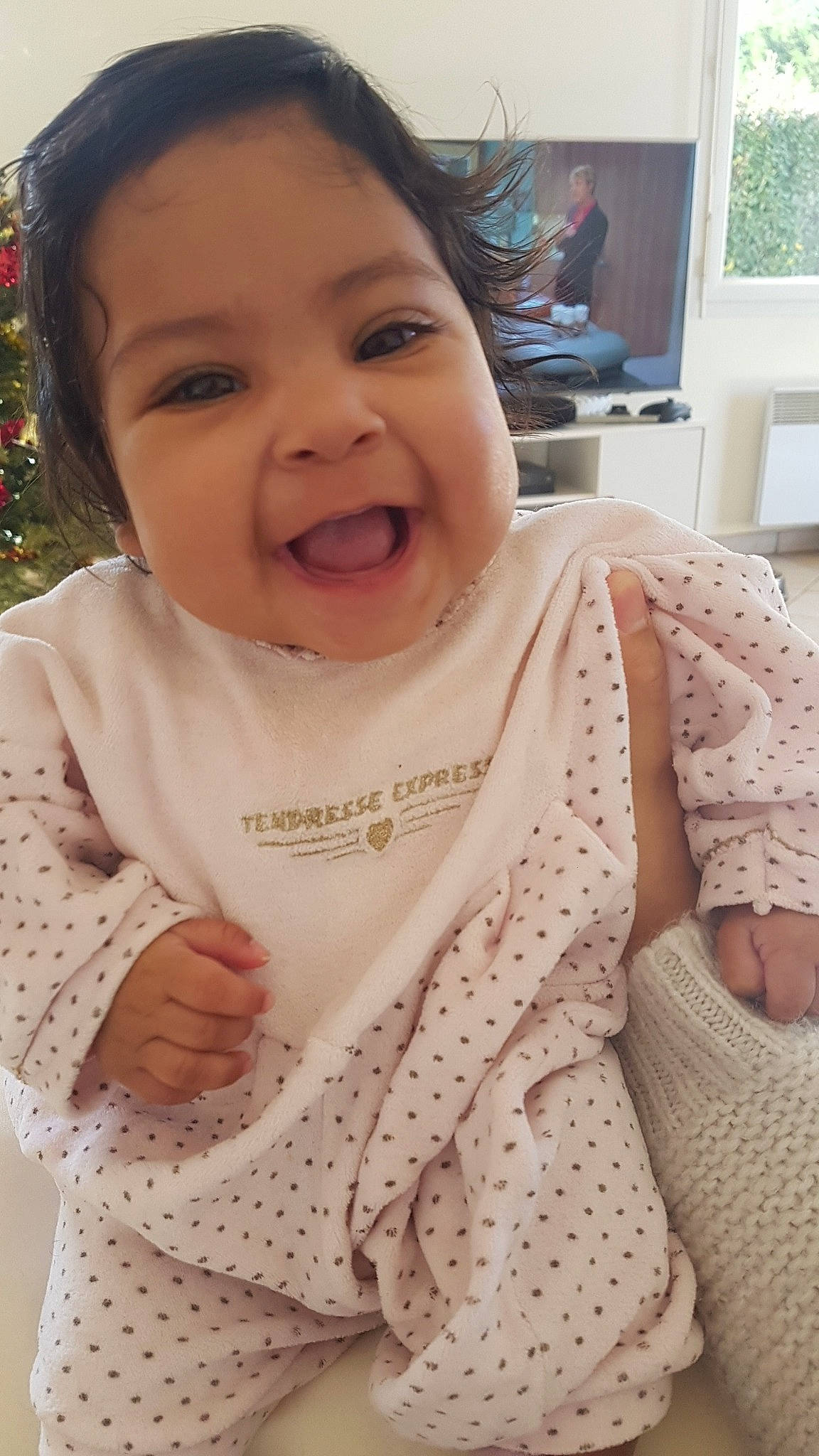 Kalyani participe au concours pour gagner de l'argent avec cette photo : baby, baby_toddler_clothing, cheek, christmas_tree, face, happy, head, iris, linens, lip, nose, outerwear, pattern, person, picture_frame, pink, skin, sleeve, smile, toddler