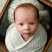 Caden is registered to the contest to win money with this photo: adorable, baby, basket, blanket, child, close_up, cozy, eyes, face, indoors, infant, knitted, looking_at_camera, newborn, photography, portrait, soft_lighting, swaddled, wide_eyed, wooden_frame