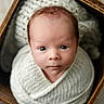 adorable, baby, basket, blanket, child, close_up, cozy, eyes, face, indoors, infant, knitted, looking_at_camera, newborn, photography, portrait, soft_lighting, swaddled, wide_eyed, wooden_frame
