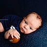 Caden is registered to the contest to win money with this photo: baby, blue_blanket, brown_hair, child, close_up, cute, eyes, face, football, hands, indoor, infant, lying_down, navy_clothing, photography, portrait, smiling, soft_lighting, sports_ball, watermark