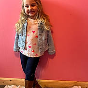 Riley joined the competition — help win amazing prizes! child, girl, smiling, pink_wall, denim_jacket, heart_shirt, long_hair, brown_boots, leggings, knit_rug, wooden_baseboard, standing, portrait, indoor, casual_clothing, cheerful, leaning, blond_hair, full_body, happy