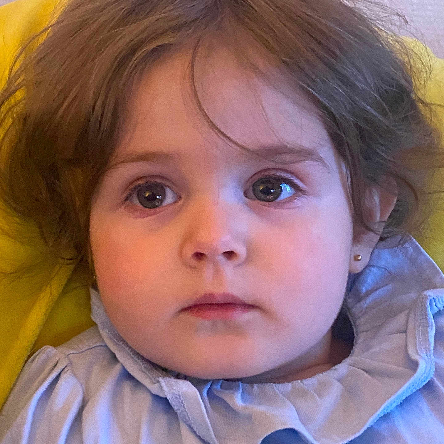 Victoire participe au concours pour gagner de l'argent avec cette photo : child, portrait, face, eyes, hair, blue_clothing, ruffled_collar, earrings, expressionless, indoor, yellow_background, closeup, young_child, cute, skin, person, baby, head, innocent, soft_lighting