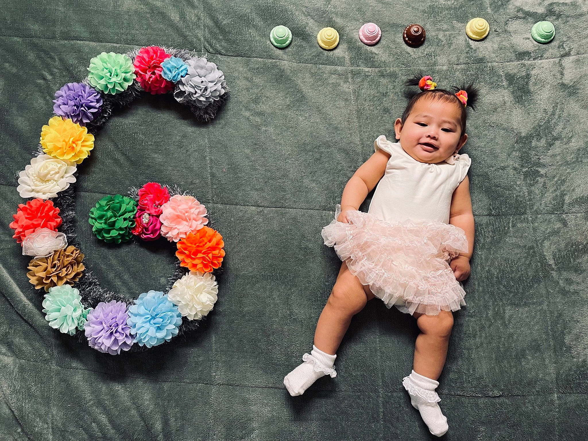 Skye is registered to the contest to win money with this photo: artificial_flower, baby, baby_toddler_clothing, beauty, cut_flowers, event, fashion_accessory, flooring, flower, flower_arranging, fun, happy, magenta, pattern, person, petal, pink, plant, textile, toddler