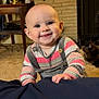 Kyrah joined the competition — help win amazing prizes! baby, child, smiling, indoor, cozy, striped_clothing, overalls, carpet, lamp, table, cat, fireplace, brick_wall, furniture, person, portrait, happy, curious, hand, home