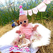 Elena joined the competition — help win amazing prizes! baby, birthday, party_hat, pink_clothing, sunglasses, teddy_bear, blanket, outdoor, grass, flowers, wildflowers, celebration, half_birthday, smiling, child, cute, nature, sunny, accessories, fun