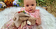 Elena is registered to the contest to win money with this photo: baby, infant, birthday_hat, pink_dress, plush_toy, bunny, blanket, flowers, banner, outdoor, grass, teddy_bear, cute, celebration, child, portrait, smiling, nature, happy, festive