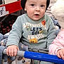 aisle, baby, blanket, blue, child, clothing, curious, cute, expression, face, green, hand, hat, indoor, person, shopping_cart, store, sweater, toddler, wine_bottles