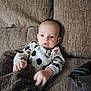 Enzo is registered to the contest to win money with this photo: baby, infant, mickey_mouse, onesie, blanket, couch, sofa, remote_control, furniture, indoors, child, person, cute, young, comfortable, resting, clothing, expression, head, hand