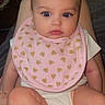 Nova joined the competition — help win amazing prizes! baby, infant, pink_bib, hearts, socks, strawberry_pattern, cute, child, portrait, indoor, seated, clothing, looking, wide_eyes, soft_lighting, skin, person, young, adorable, cozy
