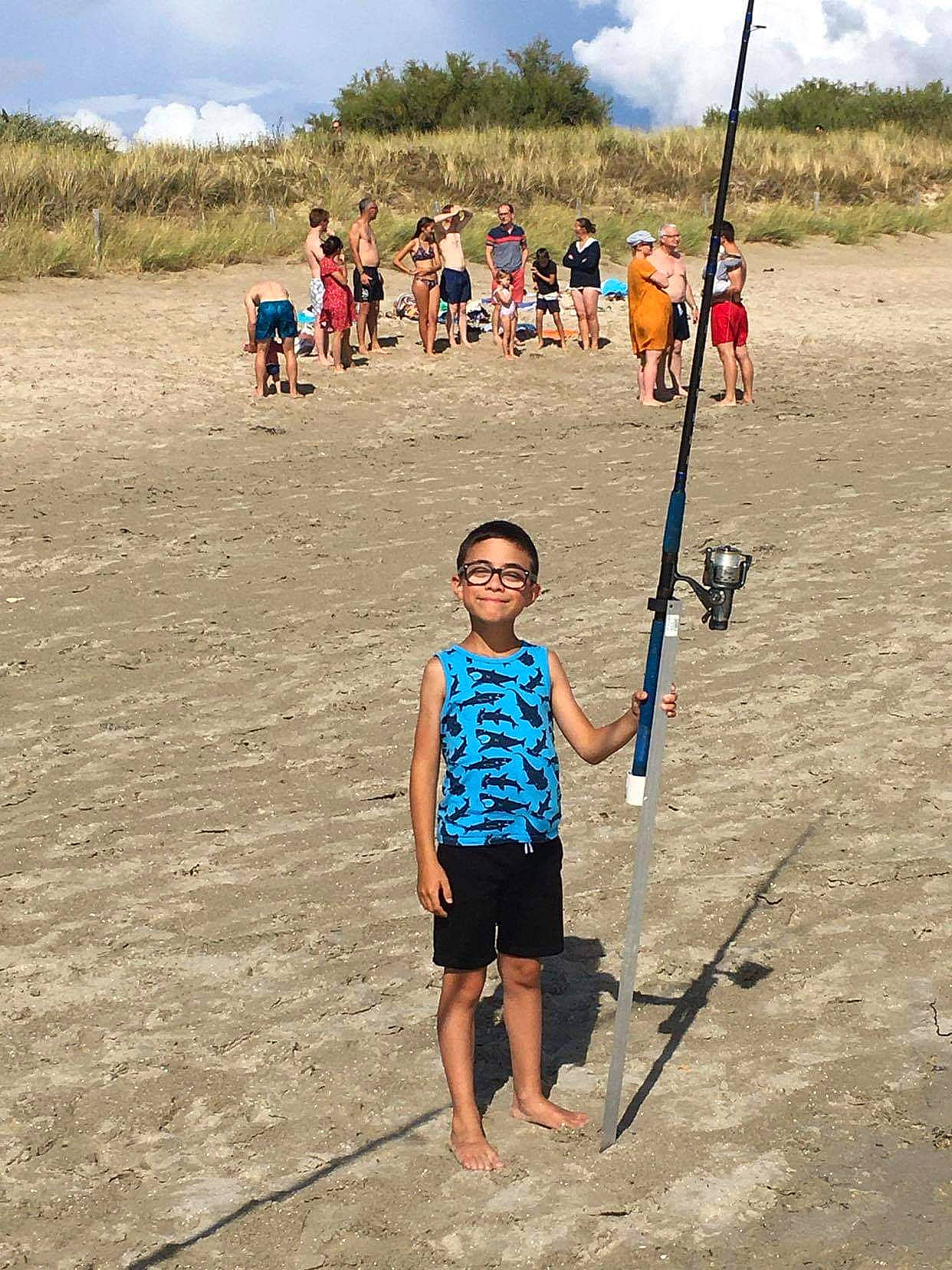 Nolann a rejoint le concours — aidez-le/la à gagner de superbes lots ! boats_and_boating_equipment_and_supplies, clothing, cloud, fun, grassland, hiking_equipment, joy, landscape, leisure, outdoor_recreation, people_in_nature, person, plant, recreation, sand, shore, shorts, sky, summer, t_shirt