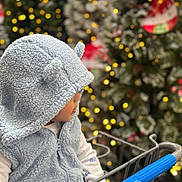 Dashiel Mathias is registered to the contest to win money with this photo: toddler, child, hoodie, blue, shopping_cart, holiday, christmas_tree, lights, bokeh, winter_clothing, cute, profile, fuzzy, ears, indoor, seasonal, decorations, festive, baby, person